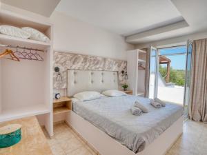 a bedroom with a large bed and a balcony at Kochylari Apartments in Kefalos