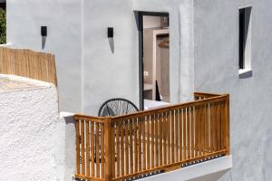 a wooden balcony with a bench on a building at Petit Suite in Emporio