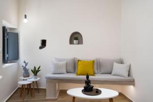a living room with a couch with a yellow pillow at Petit Suite in Emporio