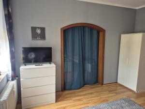 a room with a dresser and a blue curtain at Flensburg City 4 1 in Flensburg