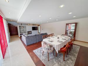 a dining room with a table and a couch at Villa Travessa das Lages in Vieira do Minho