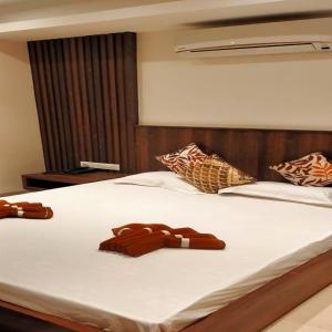 a bed with two brown towels on top of it at Eennra Kaansabbati in Medinīpur