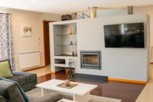 a living room with a couch and a fireplace at Villa Travessa das Lages in Vieira do Minho