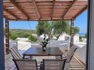 a patio with a table and chairs on a deck at Kochylari Apartments in Kefalos