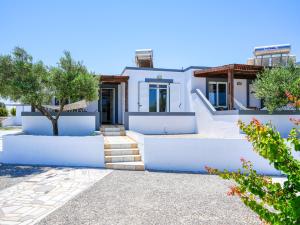 a white house with blue walls and stairs at Kochylari Apartments in Kefalos