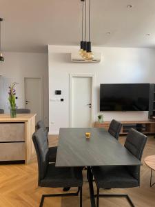 a dining room with a table and chairs and a tv at The White House Split in Split