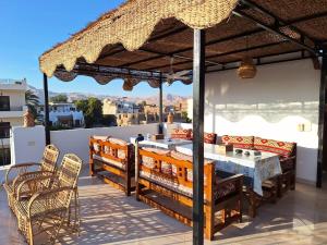 a patio with a table and chairs and an umbrella at CASA LOKO Guest House in Luxor