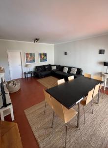 a living room with a black table and chairs at Soltroia Housefeelings in Troia