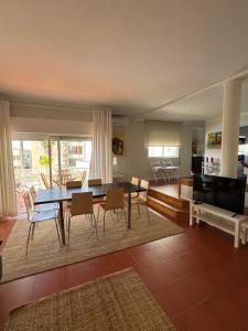 a living room with a dining room table and chairs at Soltroia Housefeelings in Troia