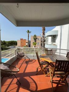 a patio with a table and chairs on a balcony at Soltroia Housefeelings in Troia