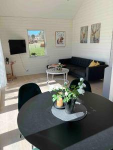 a living room with a table and a couch at Reinholds Gästhus in Kareby