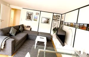ein Wohnzimmer mit Sofa und Fernseher in der Unterkunft Java Themed flat near Zoo in Aalborg