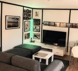 ein Wohnzimmer mit Sofa und Flachbildfernseher in der Unterkunft Java Themed flat near Zoo in Aalborg + 1 Foto