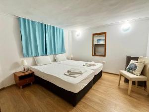 a bedroom with a large bed and a chair at hostel FARA in Nesebar