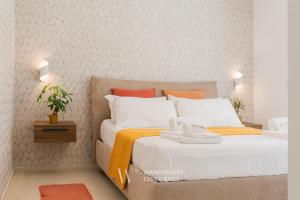a bedroom with two beds with orange and white pillows at Wanderlust Experience Villa Milly in Giovinazzo