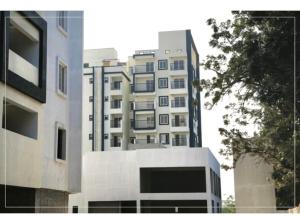 a tall white building in front of a building at North scape 104 in Bangalore