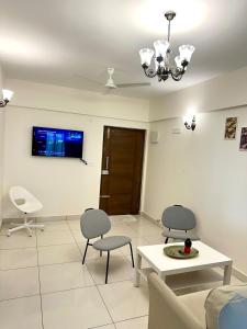 a living room with two chairs and a table and a tv at North scape 104 in Bangalore