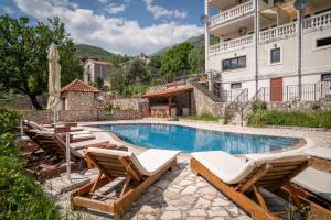 a swimming pool with lounge chairs and a building at Apartments Oasis in Budva