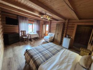 a bedroom in a log cabin with a bed and a desk at Княжий двір in Yaremche +124 photos