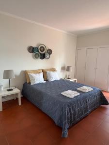 a bedroom with a large bed with two tables and two lamps at Soltroia Housefeelings in Troia +27 photos