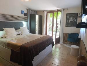 a bedroom with a bed and a sliding glass door at le frangipanier in Le Barroux