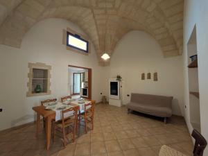 a living room with a table and chairs and a couch at Casa Santa Iaca in Vitigliano