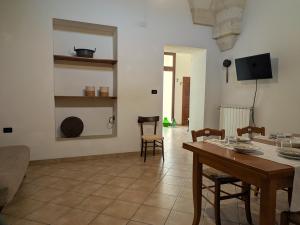 a living room with a table and chairs and a television at Casa Santa Iaca in Vitigliano