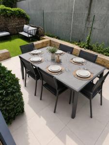 a gray table with chairs and plates on it at Bleu d'Aubrac Climatisé in Marvejols +1 photo