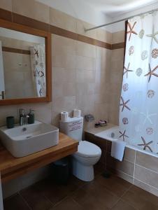 a bathroom with a sink and a toilet and a tub at Tesoro of Ithaca in Stavros +36 photos