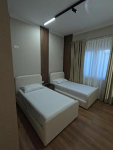 a hotel room with two beds and a window at Vila 1985 in Tirana