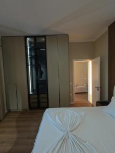 a bedroom with a white bed and a large window at Vila 1985 in Tirana +28 photos