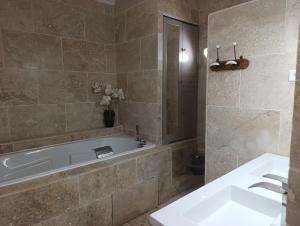 a bathroom with a tub and a sink at le frangipanier in Le Barroux +75 photos