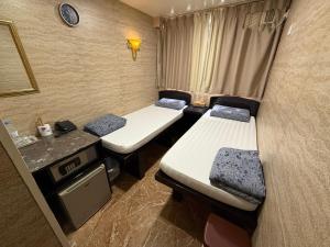 a small room with two beds and a sink at Sleep Inn in Hong Kong