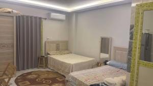 a bedroom with two twin beds and a window at Rahej home in Bandar al Manşūrah