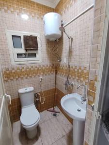 a bathroom with a toilet and a sink at Rahej home in Bandar al Manşūrah