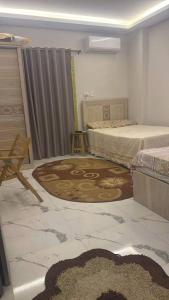 a room with two beds and a rug at Rahej home in Bandar al Manşūrah