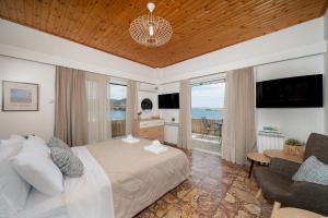 a bedroom with a bed and a tv and a couch at Porto Marina SeaView in Porto Rafti