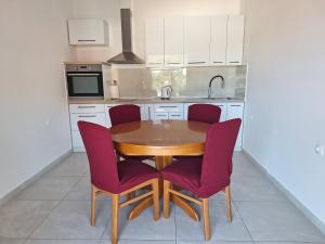 a kitchen with a wooden table and purple chairs at Accommodation Drasko in Korčula +75 photos