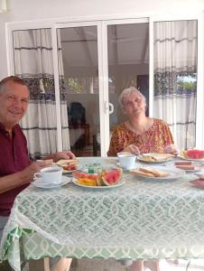 an older couple sitting at a table eating food at Steur Villa in Kepungoda