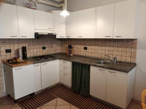 a kitchen with white cabinets and a sink at levIole in Belfiore