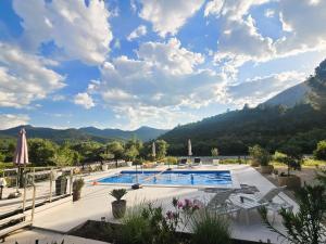 a resort swimming pool with mountains in the background at Villa Krivokapic in Trebinje