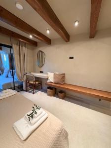 a bedroom with two beds and a bench in a room at Olive Grove Retreat Paxos in Vlachopoulátika