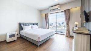 una camera da letto con un letto e una grande finestra di Tittower a Bangkok