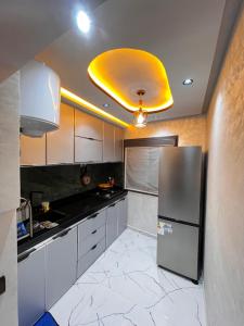 a kitchen with a refrigerator and a yellow ceiling at Stoph in Beni Mellal