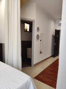 ein Schlafzimmer mit einem weißen Bett und ein Badezimmer in der Unterkunft Li Brilli in Felline + 135 Fotos