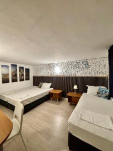 a hotel room with two beds and a table and chairs at hostel FARA in Nesebar