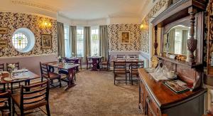 a restaurant with tables and chairs in a room at Tower Hotel in Oxton