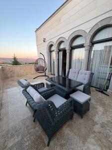 a patio with wicker furniture and a table and chairs at Duruer Living Home in Ürgüp