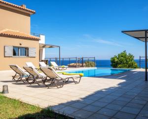 a villa with a swimming pool and patio furniture at Villa Ilias in Skala