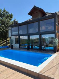 a swimming pool in front of a house at Apartmani Nase brdo in Guča